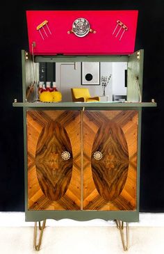 an old fashioned cabinet has been painted pink and green with gold details on the doors