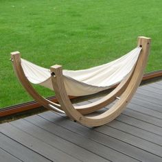 a hammock on a deck with grass in the background