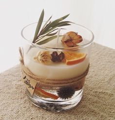 a dessert in a glass bowl with an orange slice and olive branch on the top