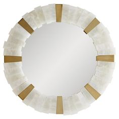 a round mirror with gold and white strips on the edges, against a white background