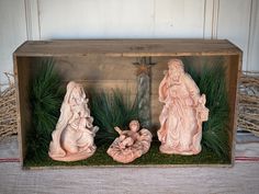 the nativity scene is displayed in a wooden box