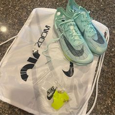 a pair of nike shoes sitting on top of a white bag