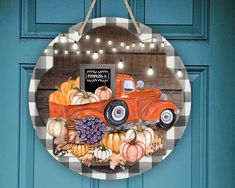 an orange truck with pumpkins and gourds hanging on a blue door