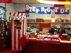 a red and white striped flag hanging from the ceiling in a library with bookshelves