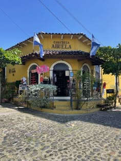 a yellow building with flags on the outside