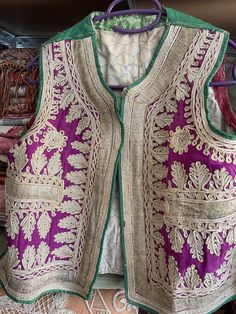 Magnifique gilet de cérémonie Ottoman  en soie époque XIXème. Cette rare pièce est en bon état et peut être  portée. Nombreuses broderies sur le devant du gilet.  La couleur rose fushia s'accorde parfaitement avec la broderie. Les dimensions : Longueur : 49 cm Sous les bras à plat : 47 cm D'épaule à épaule à plat : 37 cm ref 020623 Traditional Embroidered Festive Vest, Traditional Fitted Vest With Intricate Embroidery, Fitted Traditional Vest With Intricate Embroidery, Festival Vest With Intricate Embroidery, Traditional Festive Vest With Intricate Embroidery, Festive Bohemian Vest With Intricate Embroidery, Traditional Embroidered Vest For Wedding, Traditional Embroidered Wedding Vest, Traditional Festive Wedding Vest