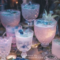 several glasses filled with different types of ice and blueberries on top of a table