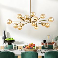 a dining room table with green chairs and a bowl of fruit