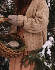 a woman holding a wicker basket in the snow