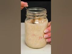 a person is holding a spoon in a jar