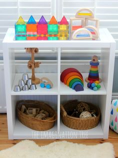 a toy shelf filled with toys on top of a wooden floor next to a white rug