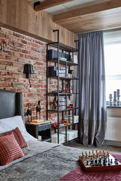 a bedroom with brick walls and a chess board on the bed