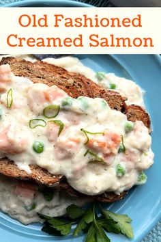 a blue plate topped with two pieces of bread covered in cream sauce and veggies