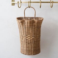 a wicker basket hanging from a coat rack