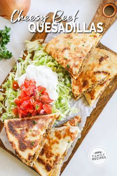 a cutting board topped with quesadillas on top of a table