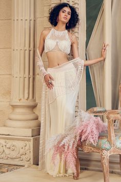 Featuring a snowy ivory draped saree in georgette and net base with cutdana and sequin hand embellishments.for a sangeet or engagement ceremony.The biggest luxury blowout end of season sale up to 70% off on statement-making sarees.#Perniaspopupshop #womenswear #ethnic #whatiworewastrending #ppuslove #sareeset #weddingwear #silk #net #handembroidery #Georgette #sequin #festivewear #engagement #sareeforwomen #printedsaree #weddingwear #sangeet #engagement Contemporary Lehenga, Sarees Modern, Modern Sarees, Ivory Drapes, Drape Sarees, Lehenga Bridal, Draped Saree, Ritu Kumar