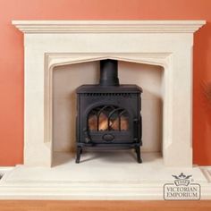 a wood burning stove sitting on top of a white mantle next to a potted plant