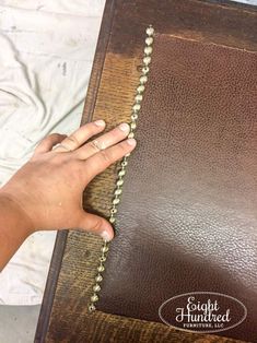 a person holding a rosary in their hand on top of a brown leather bible cover