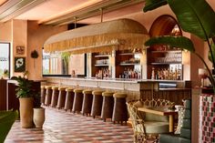 the interior of a restaurant with many chairs and bar stools in front of it