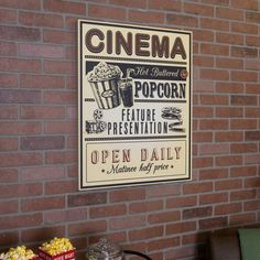 a brick wall with a sign that says cinema and popcorn