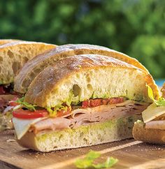 two sandwiches cut in half sitting on top of a cutting board