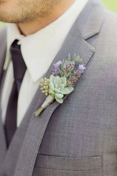 a man wearing a suit and tie with a boutonniere on his lapel