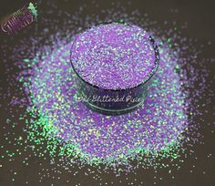 purple and green glitter powder in a glass container