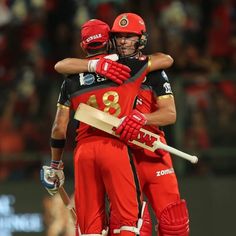 two men in red and black uniforms hugging each other with their arms around one another