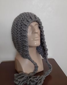 a gray crocheted hat on top of a mannequin's head