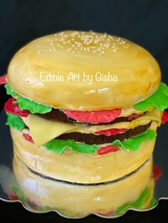 a cheeseburger is sitting on top of a glass plate with the words edible art by ghisa