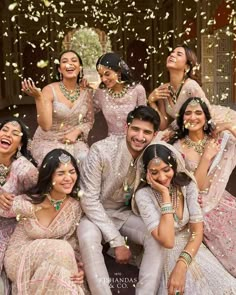 the bride and grooms are posing for a group photo with confetti thrown in the air