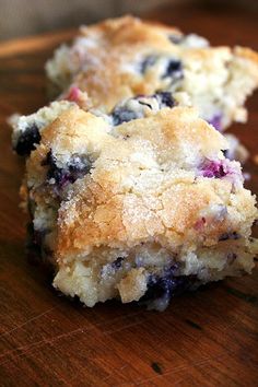 two blueberry scones sitting on top of a wooden table next to each other