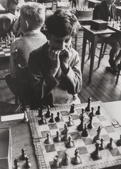 an old black and white photo of children playing chess