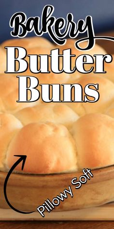 a close up of a bread in a pan on a wooden table with the words bakery butter buns below it