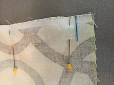 the fabric has been stitched together with two pins and some yellow beads on it