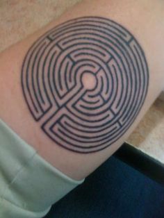 a man's arm with a tattoo on it that has a maze in the center