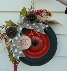 a wreath hanging on the side of a house with a happy fall sign attached to it