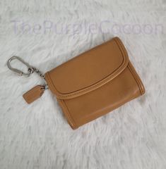 a tan leather purse with a key chain