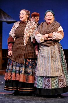 two women standing next to each other on a stage