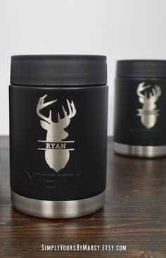 three black and silver canisters sitting on top of a wooden table next to each other