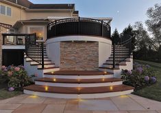 a large house with stairs leading up to it's front door and landscaping area