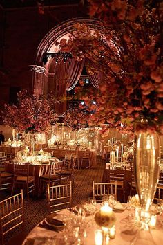 the tables are set with candles and centerpieces for an elegant wedding reception at night