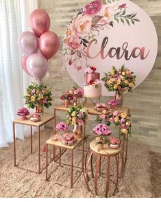 a table topped with lots of pink and yellow flowers next to a sign that says ciara