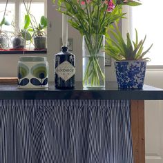 three vases filled with flowers sitting on top of a table next to a window