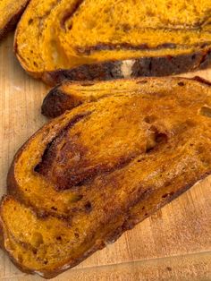 two pieces of bread sitting on top of a wooden cutting board