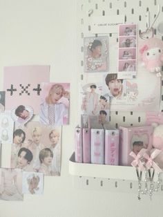 a white shelf topped with lots of pictures and magnets next to a pink teddy bear