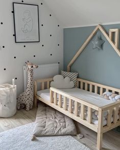 a baby's room with blue walls and white carpeted flooring, a wooden cot in the shape of a house