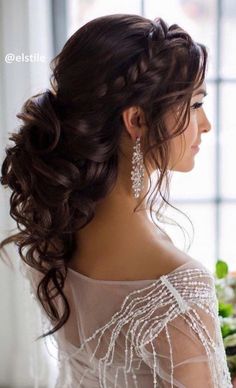 the side view of a woman's hair with braids and flowers in it