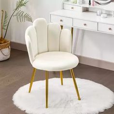 a white chair sitting on top of a rug in front of a desk and mirror