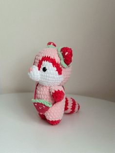 a small crocheted stuffed animal sitting on top of a white table next to a wall